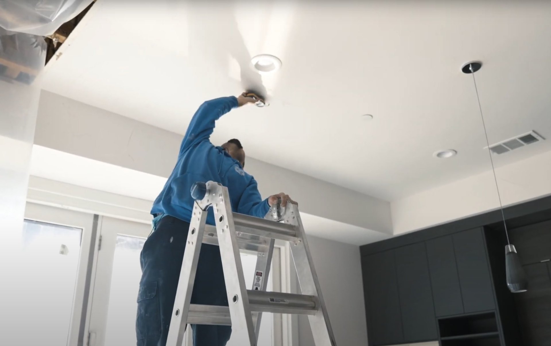 Ceiling repair and water damage prevention maintenance work Professional water damage restoration technician working on ceiling repair and maintenance